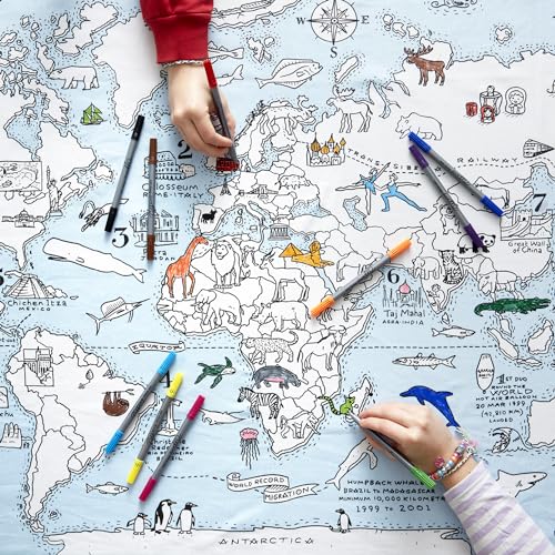 Children drawing on a table cloth with a print of the world map