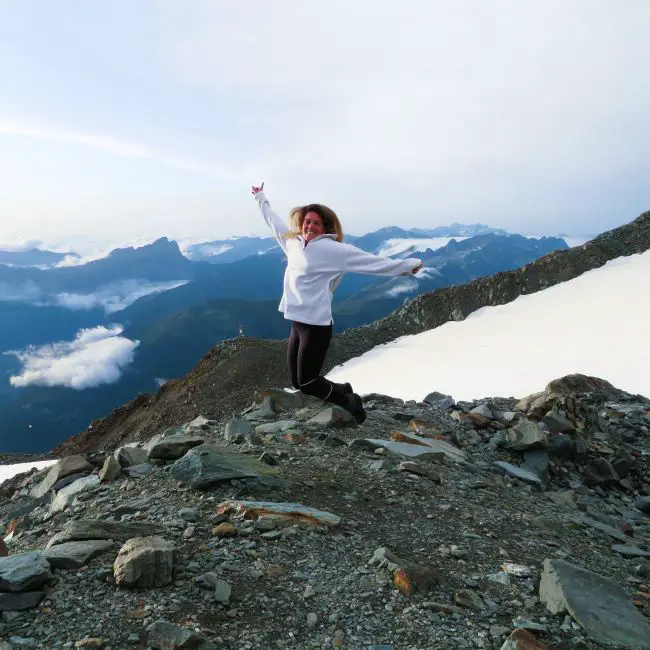 A woman jumping in the air on a mountain