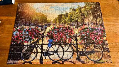 A jigsaw puzzle of a canal and bicycles in Amsterdam