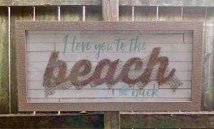 A wooden sign with "I love you to the beach and back"
