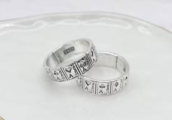 two silver rings with the aces in the four suits