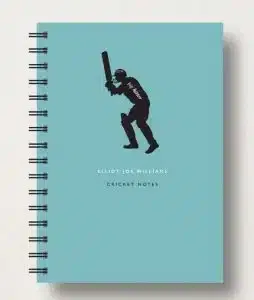 A blue notebook with a personalized cover of a cricket player