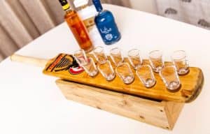 A cricket bat with shot glasses