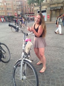 Woman standing next to a bike in Amsterdam