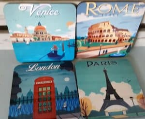 A set of coasters with a print of vintage travel posters from European cities