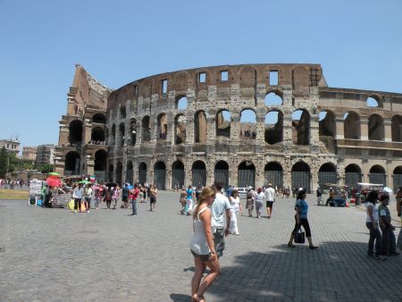 Woman walking in front of the colloseum in Rome