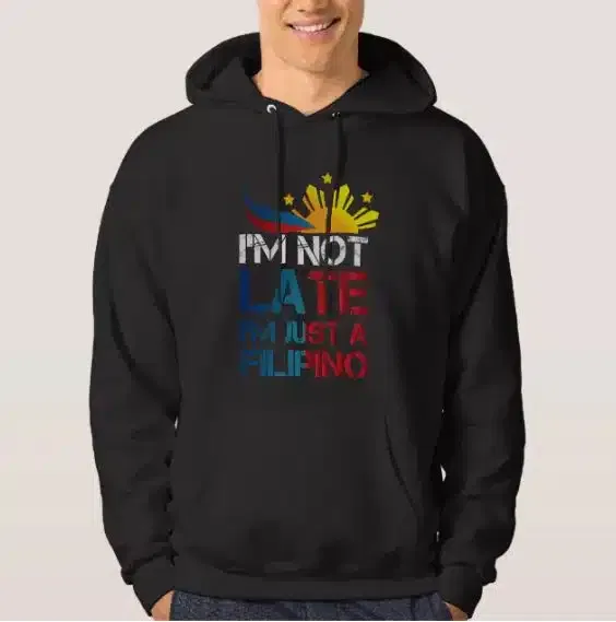 A man wearing a hoodie with the text "I am not late, I am Filipino"