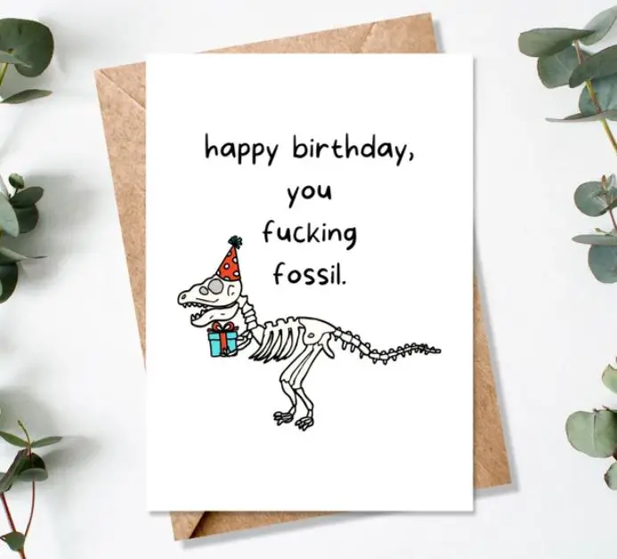 funny birthday wishes card with a skeleton of a dinosaur and "happy birthday you fing fossil"