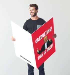 Man holding an enormous card with an image of Donald Trump and Graduating, this is huge!