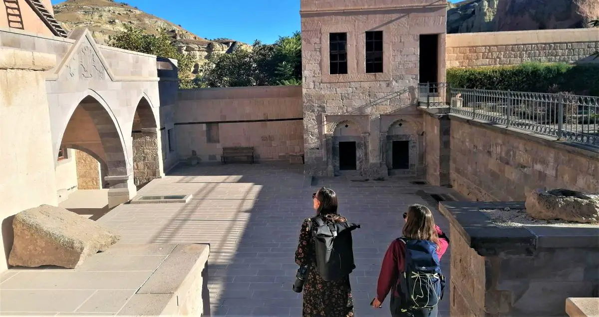 Two women with backpacks in an old monastry