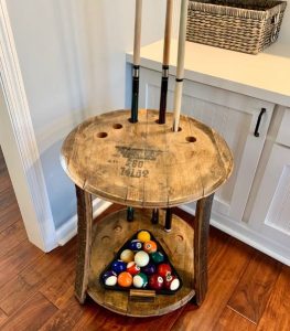 A pool balls and cue holder made from an old whiskey barrel