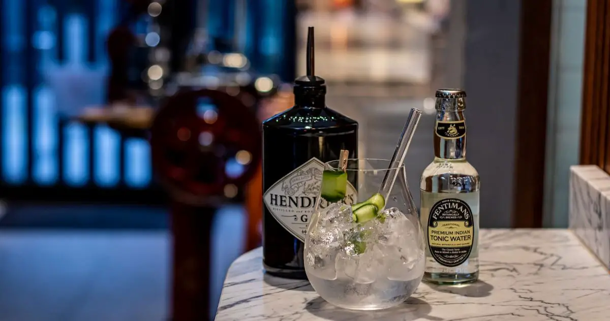Bottle of gin with a glass of gin tonic