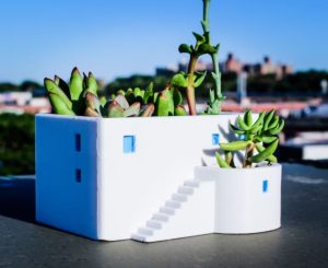 A planter shaped like a white house on a Greek island