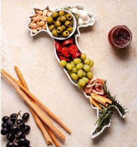 A white serving tray with food that is shaped like the map of Italy