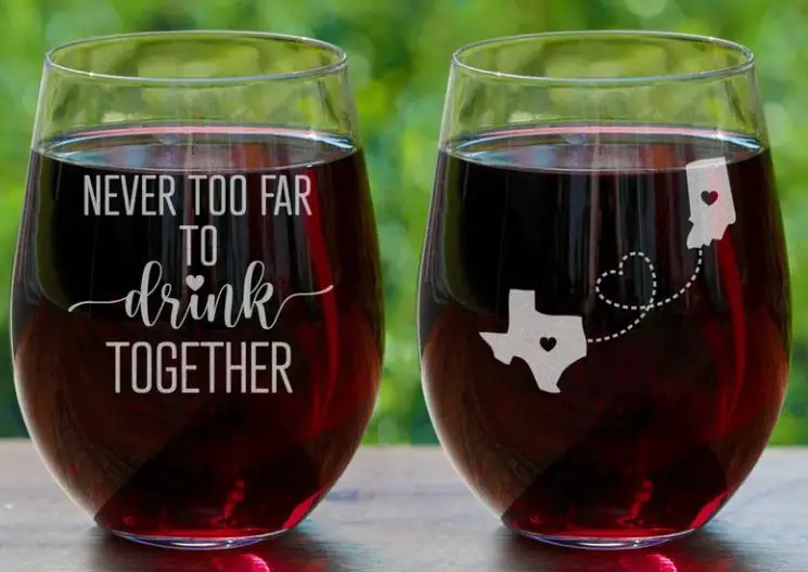 Two wine glasses with text etched "never too far to drink together" great as long-distance gifts for friends who love wine