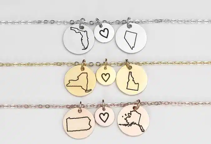 Three necklaces with pendants of a heart and the maps of US states
