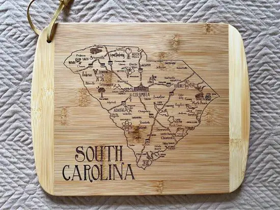 A bamboo cutting board with the map of South carolina etched