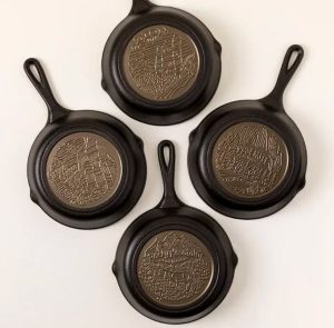 Four cast iron pans with a national park-themed bottom