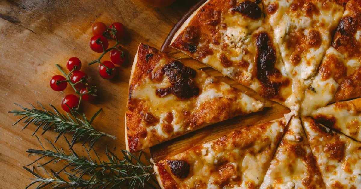 gifts for pizza lovers A pizza on a wooden plate with tomatoes and herbs