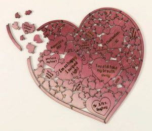 A wooden heart puzzle with sweet messages on each piece