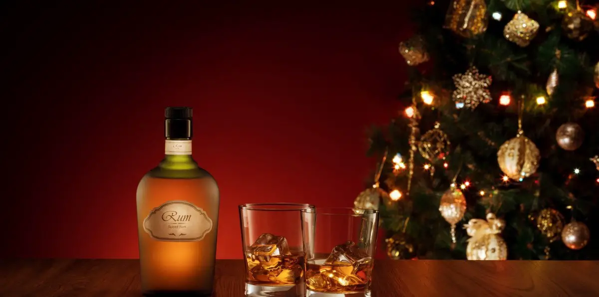 rum gifts A photo of a bottle of rum with two glasses and a Christmas tree in the background