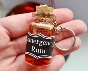 A keychian with a miniature bottle and the text "emergency rum"