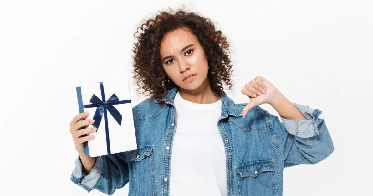 A woman holding a gift with her thumbs down